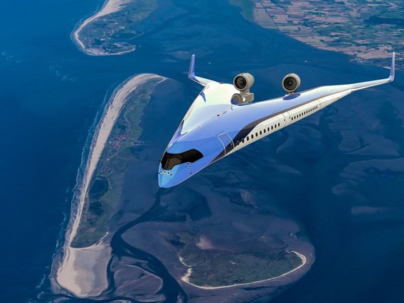 Ein futuristisches weißes Flugzeug mit ungewöhnlichem Design und rückwärtig montierten Triebwerken fliegt über eine Küstenlandschaft mit Inseln und blauem Wasser.