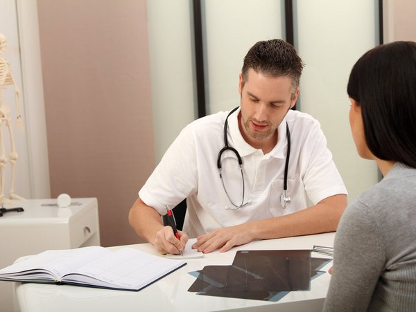 Arzt und Patientin besprechen medizinische Vorsorgeuntersuchungen in einem Büro