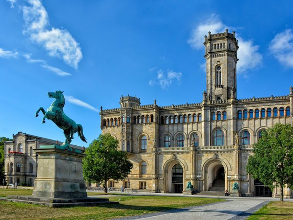 Das historische Gebäude der Universität Hannover mit dem Statue eines Pferdes im Vordergrund