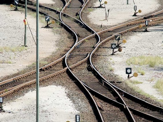 Zwei geschwungene Bahnschienen kreuzen sich und verlaufen dann wieder auseinander