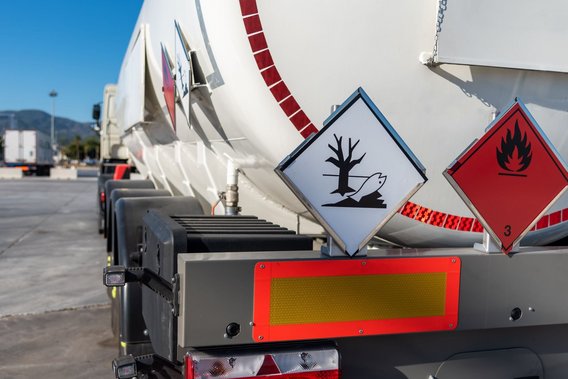 Tanklastwagen mit Gefahrgutkennzeichnungen für umweltgefährdende und entzündbare Stoffe.