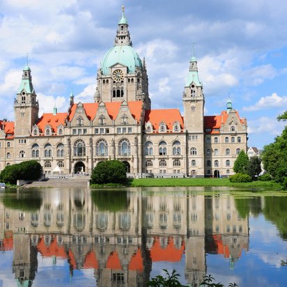 Blick auf das Neue Rathaus Hannover mit Spiegelung im Maschteich bei sonnigem Wetter