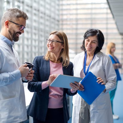 Eine Auditorin unterhält sich mit Medizinern in einer Klinik