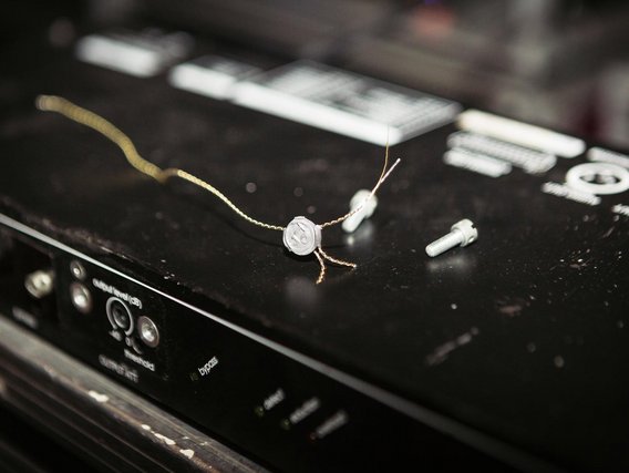 Nahaufnahme eines Audiogeräts mit freiliegenden Kabeln und einem Siegel oder Plombe, die technische Wartung oder Kalibrierung andeutet.