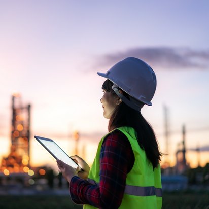 Symbolbild zum Gesetz zur Finanzierung der Energiewende im Stromsektor Mitarbeiter in Schutzkleidung vor Industrieanlage bei Dämmerung - Symbolbild zum Gesetz zur Finanzierung der Energiewende im Stromsektor