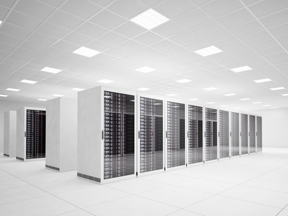 Ein modernes Rechenzentrum mit mehreren Reihen von Server-Racks in einem hellen Raum.