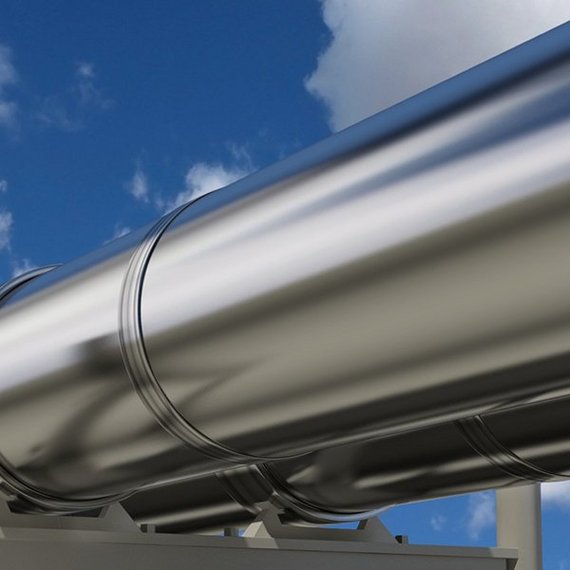 TUEV NORD Wasserstoff Pipelines Silbrig glänzende Pipeline vor blauem Himmel mit wenigen Wolken