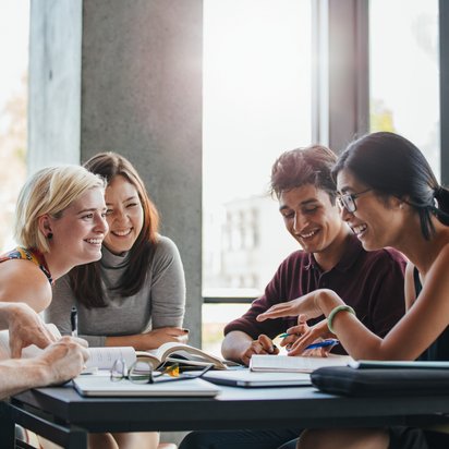 Mitarbeitende sitzen am Tisch und schreiben einen Artikel zum Thema Personalentwicklung für den TÜV NORD Blog für berufliche Weiterbildung.