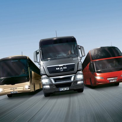 Vielfalt der Berufskraftfahrt auf der Autobahn rei große Fahrzeuge, darunter ein LKW und zwei Reisebusse, fahren nebeneinander auf einer Autobahn.
