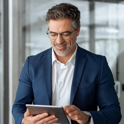 GmbH-Geschäftsführer (TÜV) Ein GmbH-Geschäftsführer sieht auf sein Tablet