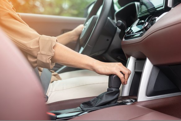Person schaltet in einem modernen Fahrzeug