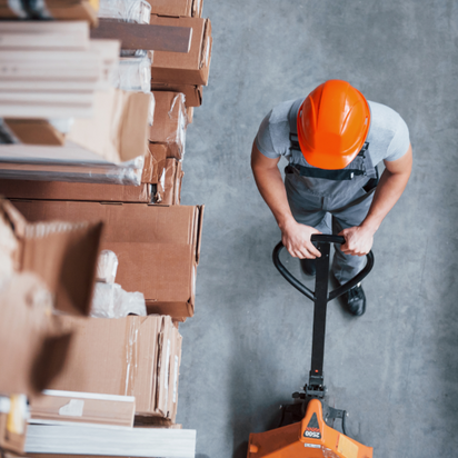 Top view eines Arbeiters im Warenhaus mit Palletenhubwagen