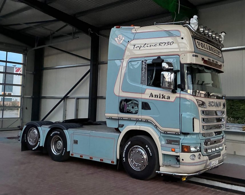 Ein hellblau und beige lackierter Scania Sattelzug, der in der Prüfanlage Kappeln-Ellenberg vom TÜV NORD steht