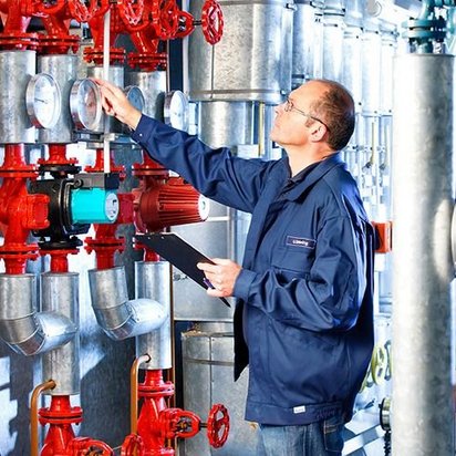 TÜV NORD Experte überprüft Messgeräte und Ventile in einer Industrieanlage.