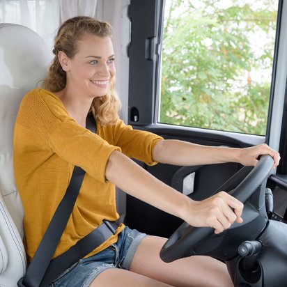 Frau am Steuer eines Wohnmobils, bereit für die Fahrt
