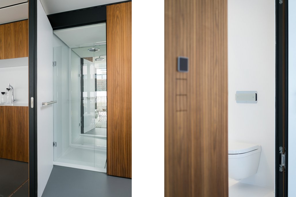 Doppelansicht eines modernen Badezimmers mit Schiebetüren aus Holz. Links ist eine Glasdusche zu sehen, rechts eine moderne Toilette mit Wandbedienfeld.