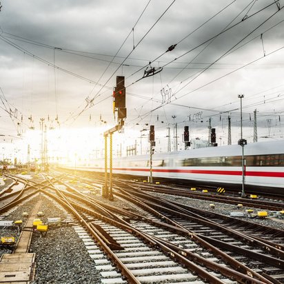 Schnellzug auf einem komplexen Gleisnetz bei Sonnenuntergang