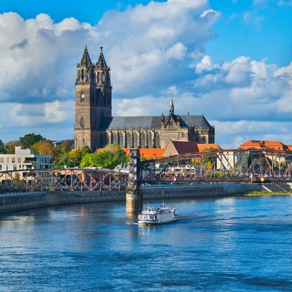 TÜV NORD Standort Magdeburg – Technische Sicherheit an der Elbe Blick auf den Magdeburger Dom und die Hubbrücke über die Elbe bei sonnigem Wetter