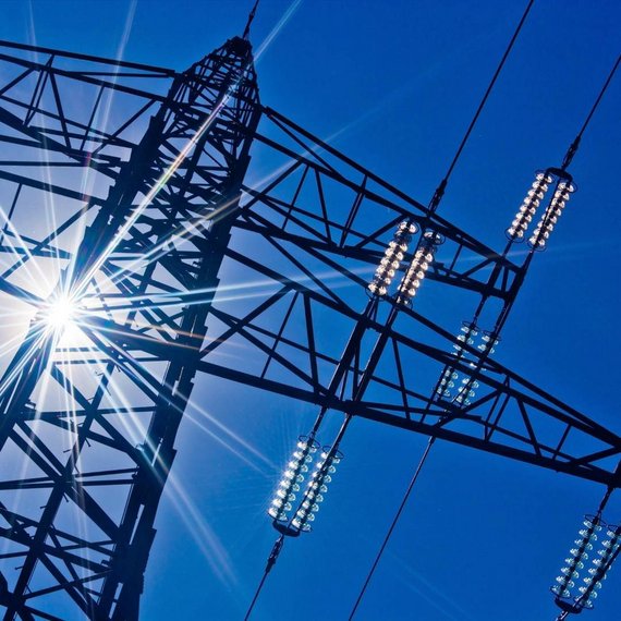 Hochspannungsmast mit Isolatoren vor blauem Himmel – Symbol für Stromnetze und Sektorkopplung