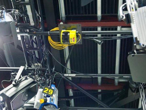 Technische Installationen an einer Decke mit Kabelführungen, darunter ein gelber Kasten mit der Nummer 29 an einem Gerät.