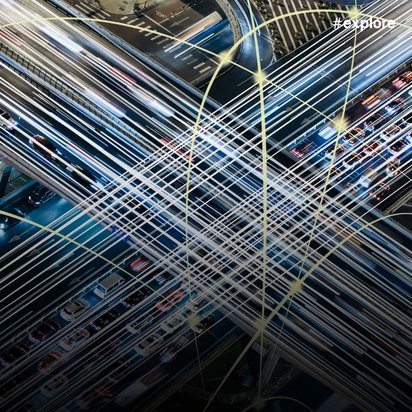 Luftaufnahme eines komplexen Autobahnkreuzes bei Nacht, mit übereinander kreuzenden Straßen und Brücken. Zahlreiche Fahrzeuge mit Lichtspuren und Verbindungslinien visualisieren die Verkehrsdichte und Vernetzung.