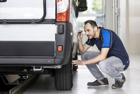 Prüfingenieur inspiziert die Reifen eines Wohnmobils