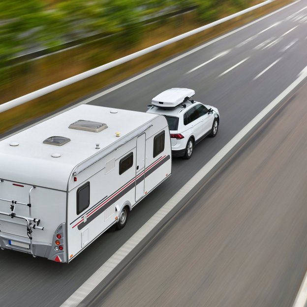 Wohnwagen mit Auto auf Straße
