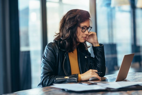 Frau arbeitet konzentriert am Laptop in einem modernen Büro