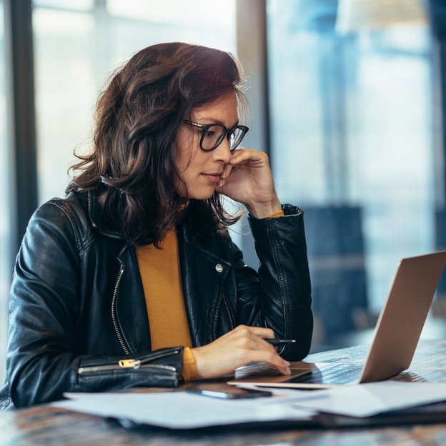 Frau arbeitet konzentriert am Laptop in einem modernen Büro