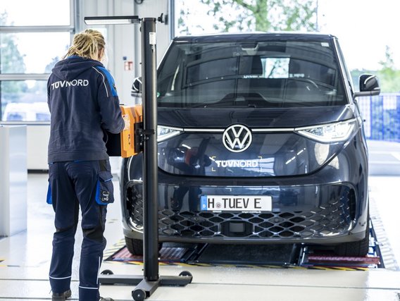 Prüfingenieurin bei der Scheinwerferprüfung an einem Fahrzeug an der TÜV NORD Station