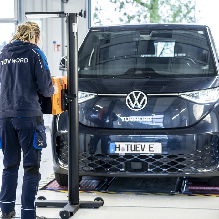 Prüfingenieurin bei der Scheinwerferprüfung an einem Fahrzeug an der TÜV NORD Station