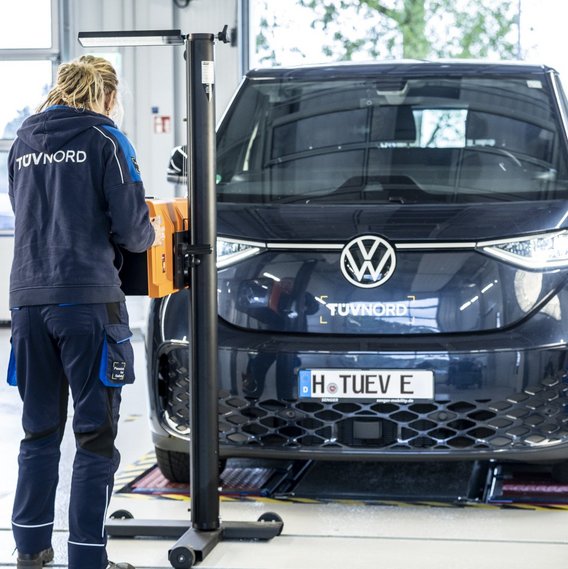 Prüfingenieurin bei der Scheinwerferprüfung an einem Fahrzeug an der TÜV NORD Station
