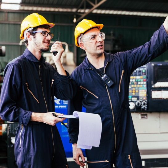 Two employees monitor and coordinate production.
