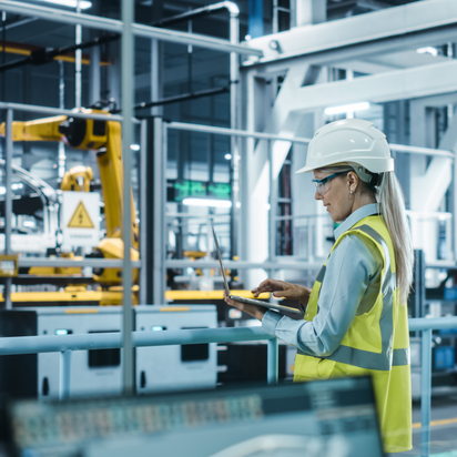 Tabletgestützte Überwachung automatisierter Produktionsanlagen mit Industrierobotern in moderner Fertigung.