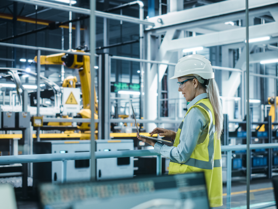 Tabletgestützte Überwachung automatisierter Produktionsanlagen mit Industrierobotern in moderner Fertigung.