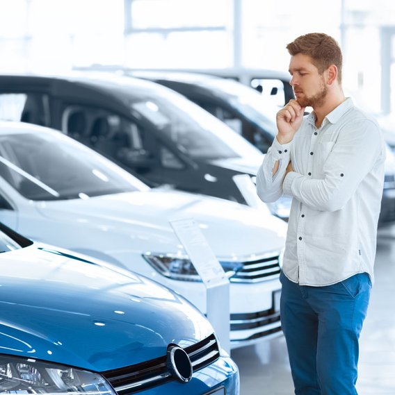 Person betrachtet Autos in einem Autohaus