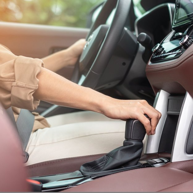 Person schaltet in einem modernen Fahrzeug