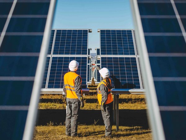 Zwei Techniker prüfen Solarpanels in einer Anlage