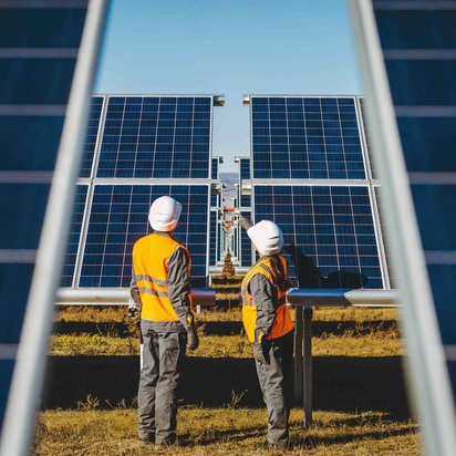 Zwei Techniker prüfen Solarpanels in einer Anlage