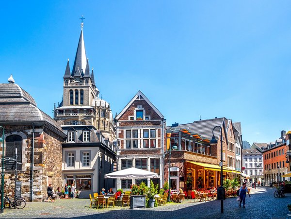 Blick auf historische Gebäude und Straßencafés in der Altstadt von Aachen bei Sonnenschein