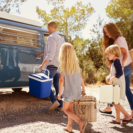 Familie bereitet sich auf Campingreise mit einem klassischen VW-Bus vor