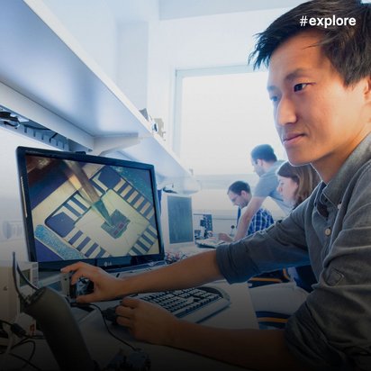 Ein junger Mann analysiert Daten an zwei Bildschirmen - links zeigt ein Oszilloskop Wellenformen, rechts eine Computerplatine, in einem Elektroniklabor.