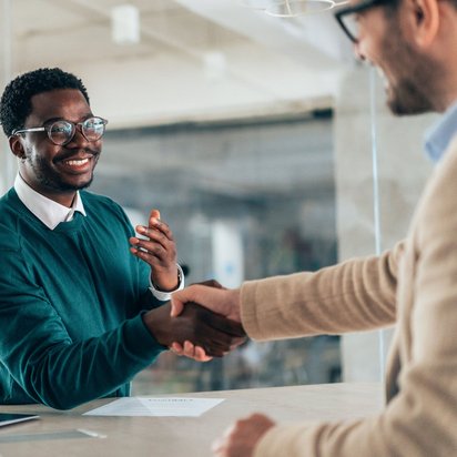 Bewerbungsgespräch mit Handschlag – Symbolbild für den Einstieg als Referent:in bei der TÜV NORD Akademie