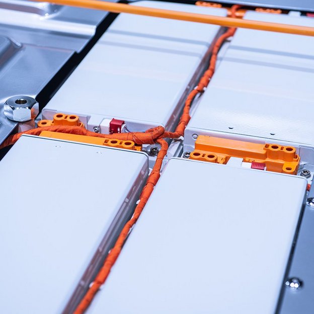  Nahaufnahme eines Hochvolt-Batteriesystems mit orangefarbenen Kabeln und Anschlüssen.