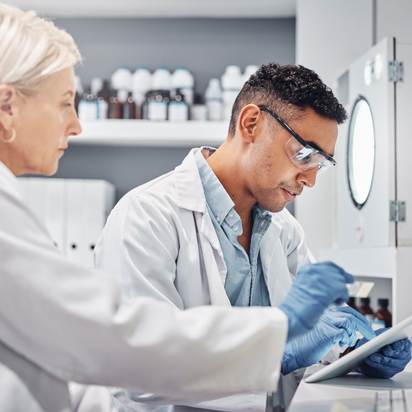 Ein Wissenschaftsteam arbeitet gemeinsam in einem Labor, betrachtet Daten auf einem Tablet