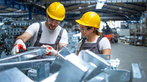 Zwei Mitarbeitende besprechen Prüfpflichten an einer Maschine.