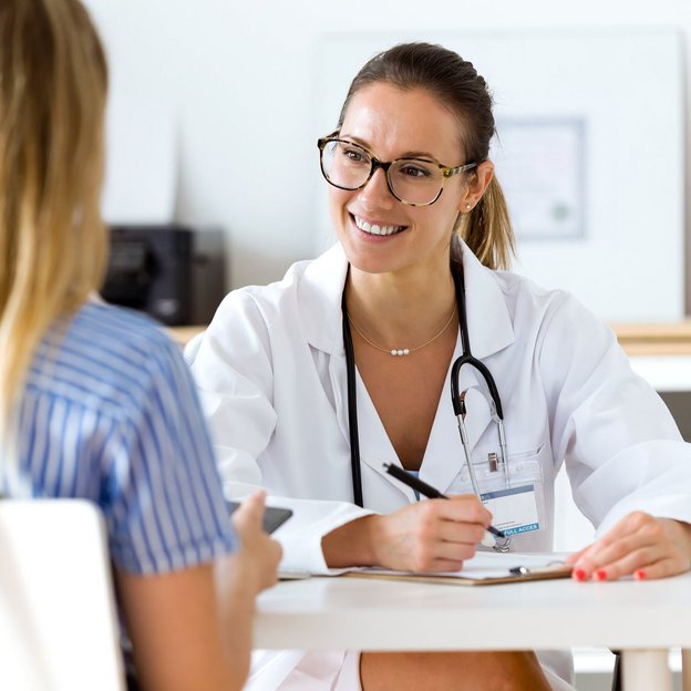 Eine Ärztin führt ein Gespräch mit einer Patientin und bietet Beratung zur Gesundheit am Arbeitsplatz