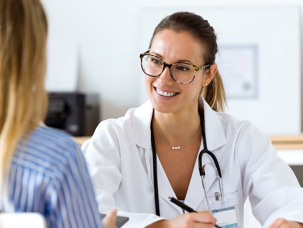 Eine Ärztin führt ein Gespräch mit einer Patientin und bietet Beratung zur Gesundheit am Arbeitsplatz
