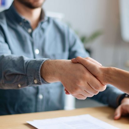 TÜV NORD Transfer - Header Vermittlung Zwei Gespärchspartner:innen schütteln die Hände