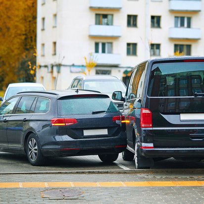 Parkrempler zwischen zwei Fahrzeugen auf einem Parkplatz